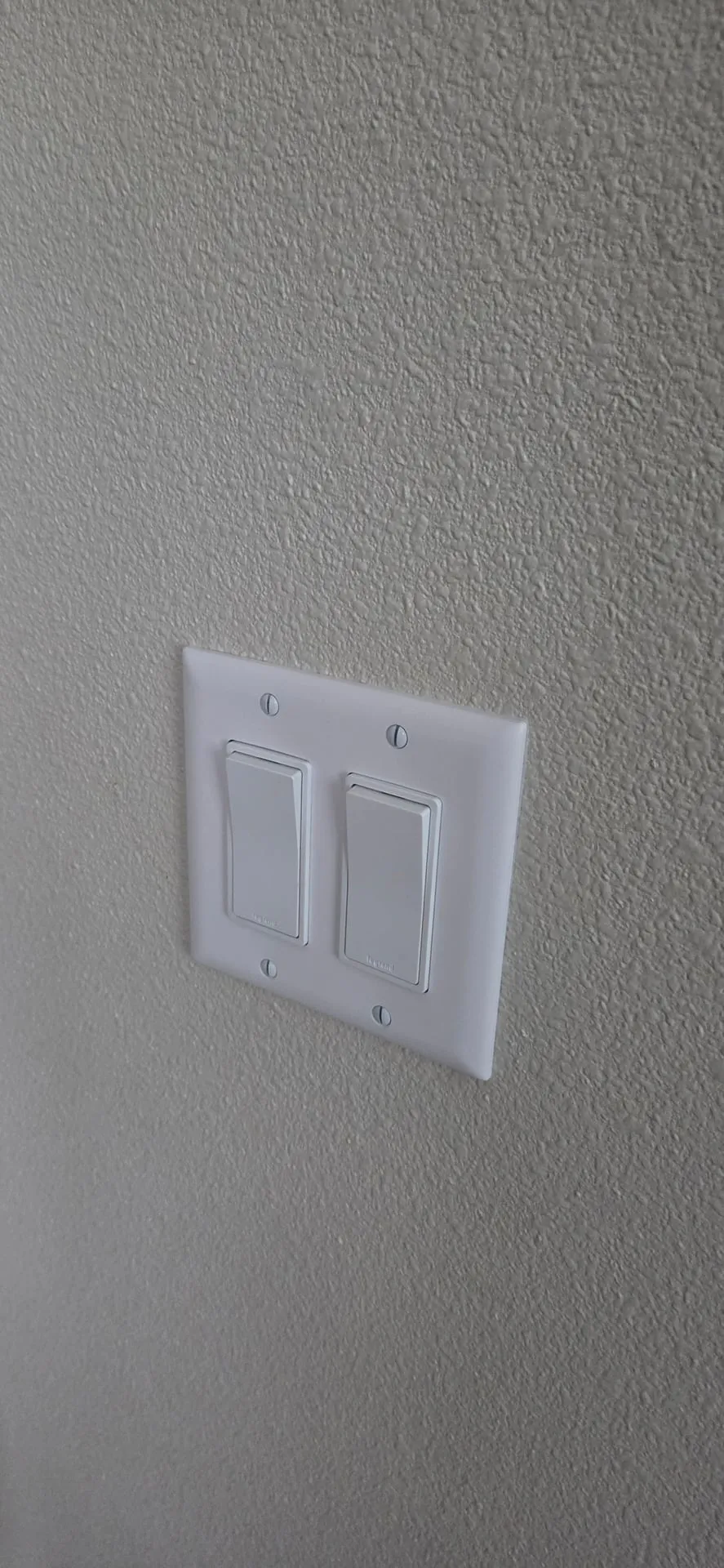 New white two-gang rocker switches with a screwless cover plate on a textured wall in a Washougal WA home