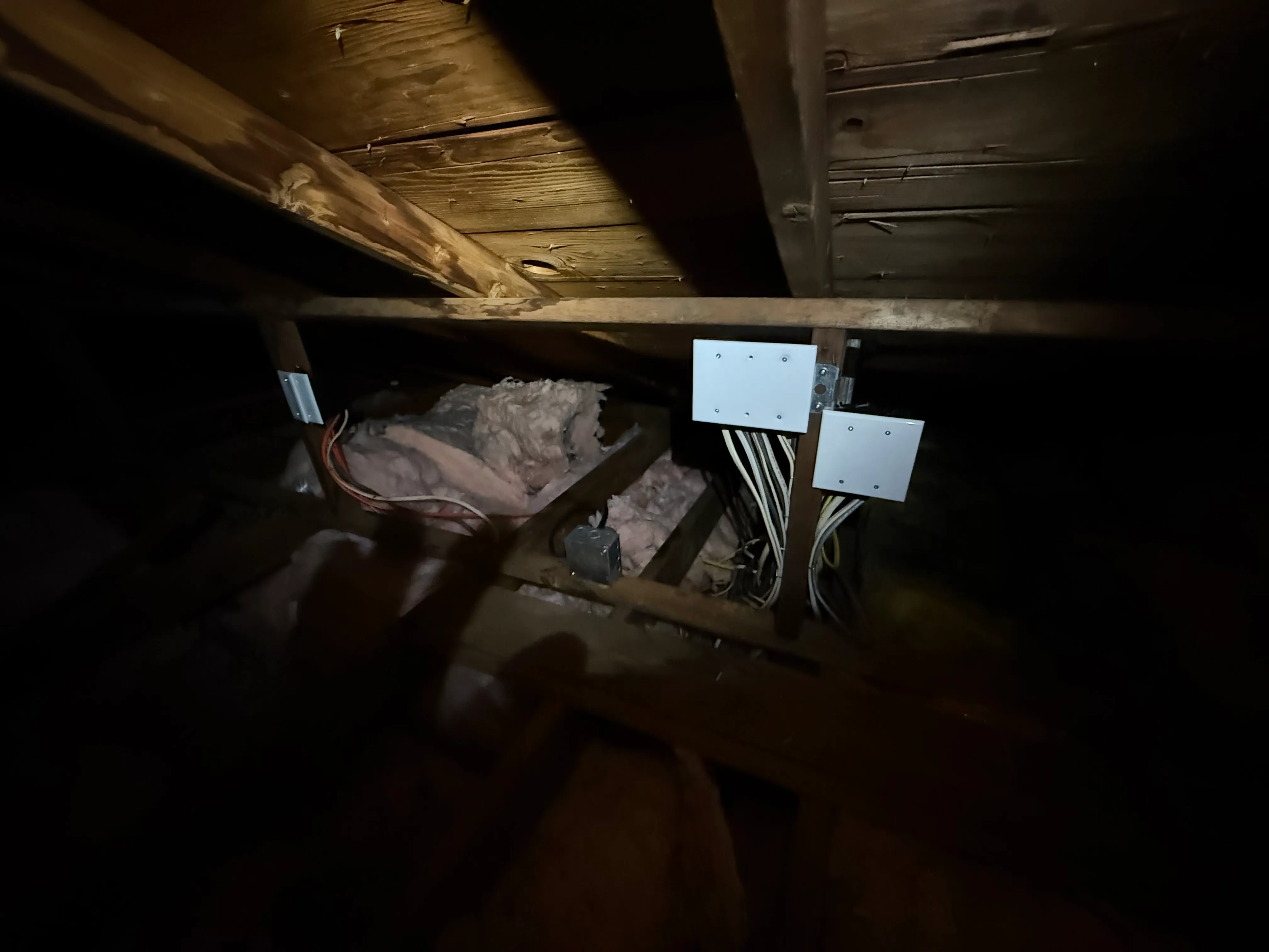 Two junction boxes mounted on framing in the attic of a Vancouver WA home where existing branch circuits were spliced and extended toward the new exterior panel