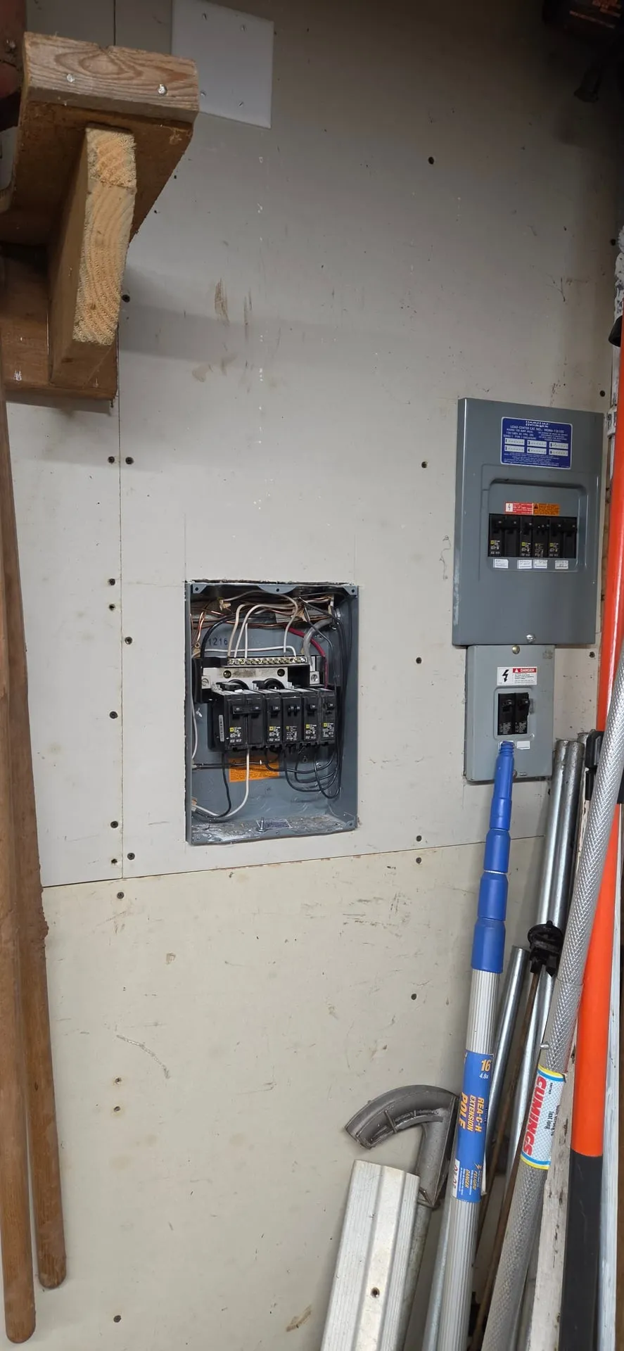 Barn subpanel with the cover on next to a second gray panel on a plywood wall in a Camas WA barn