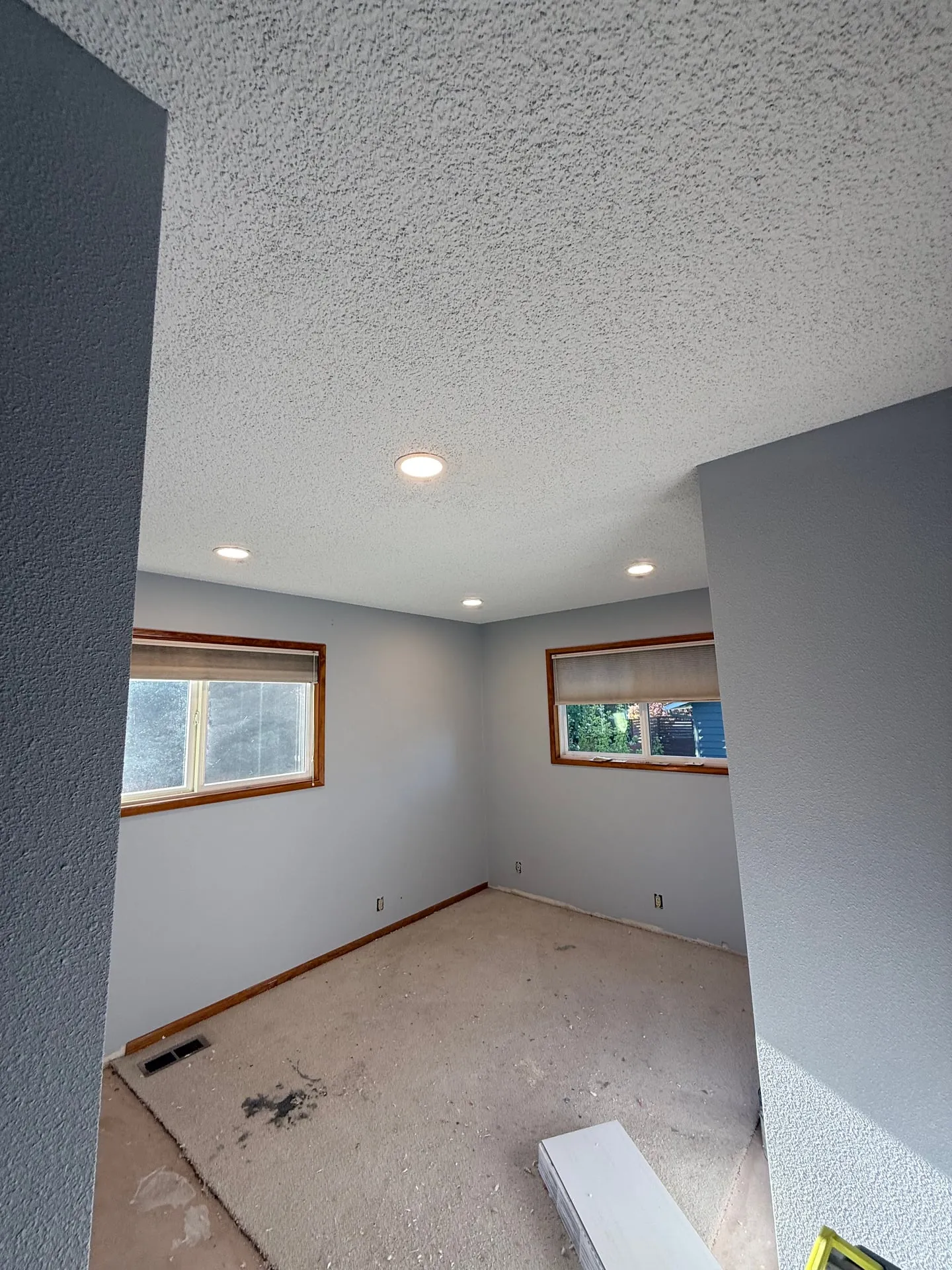 Bedroom in a Felida home in Vancouver WA at trim-out with four 6-inch recessed cans cut into the textured ceiling and fresh paint on the walls