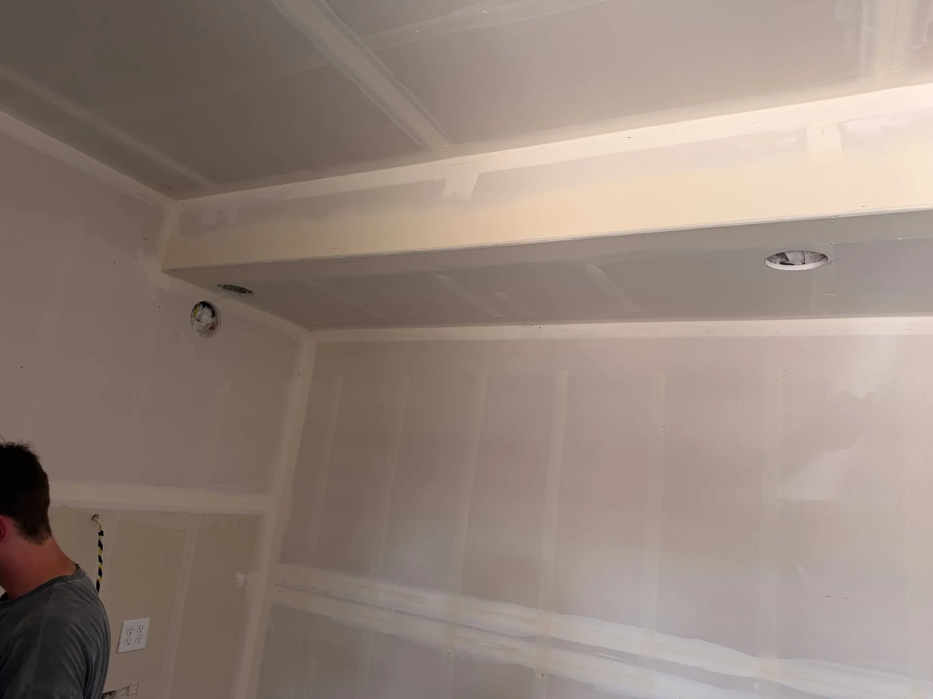 Bare drywall wall in an Orchards home in Vancouver WA at rough-in, with device boxes set and the under-cabinet lighting channel cut in above the counter line