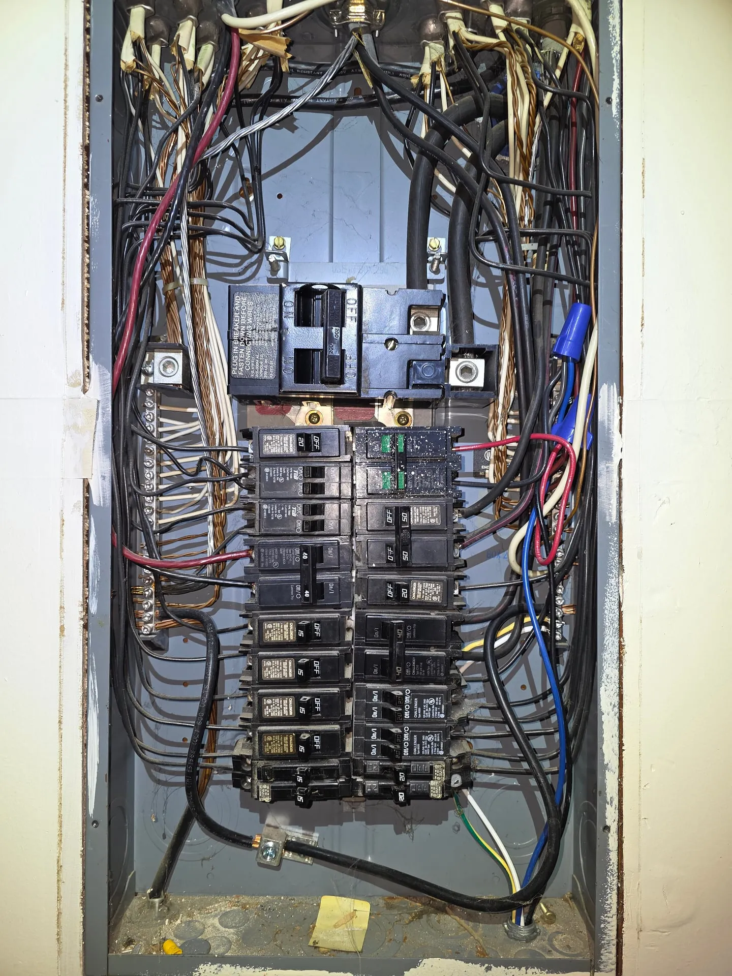 Original electrical panel in a Hazel Dell home in Vancouver WA before replacement, crowded with branch circuit conductors looping across the bus and aged breakers filling every space