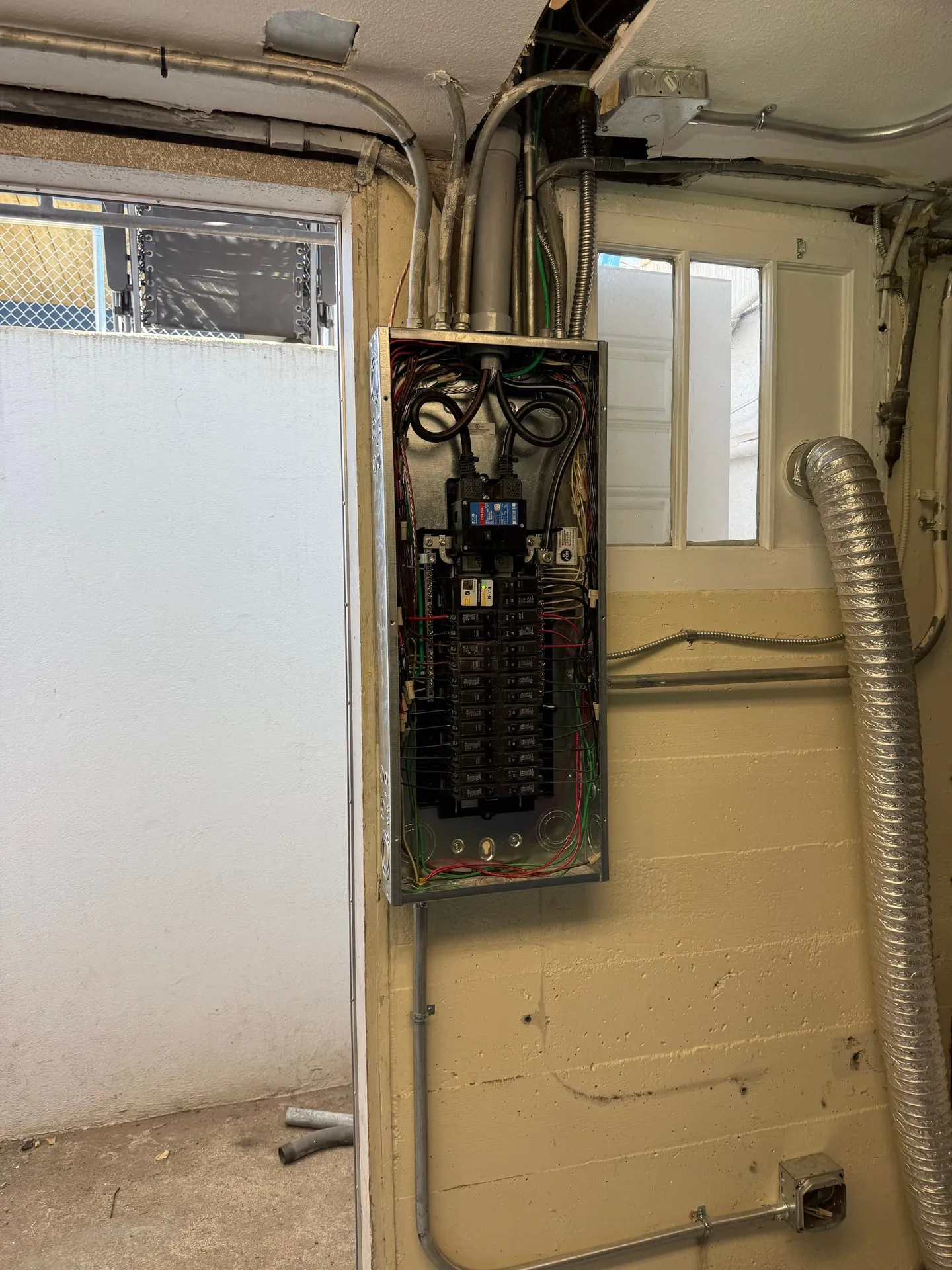 Old panel opened in the basement of an older Vancouver WA home, showing the original service equipment and the cloth-covered conductors feeding it