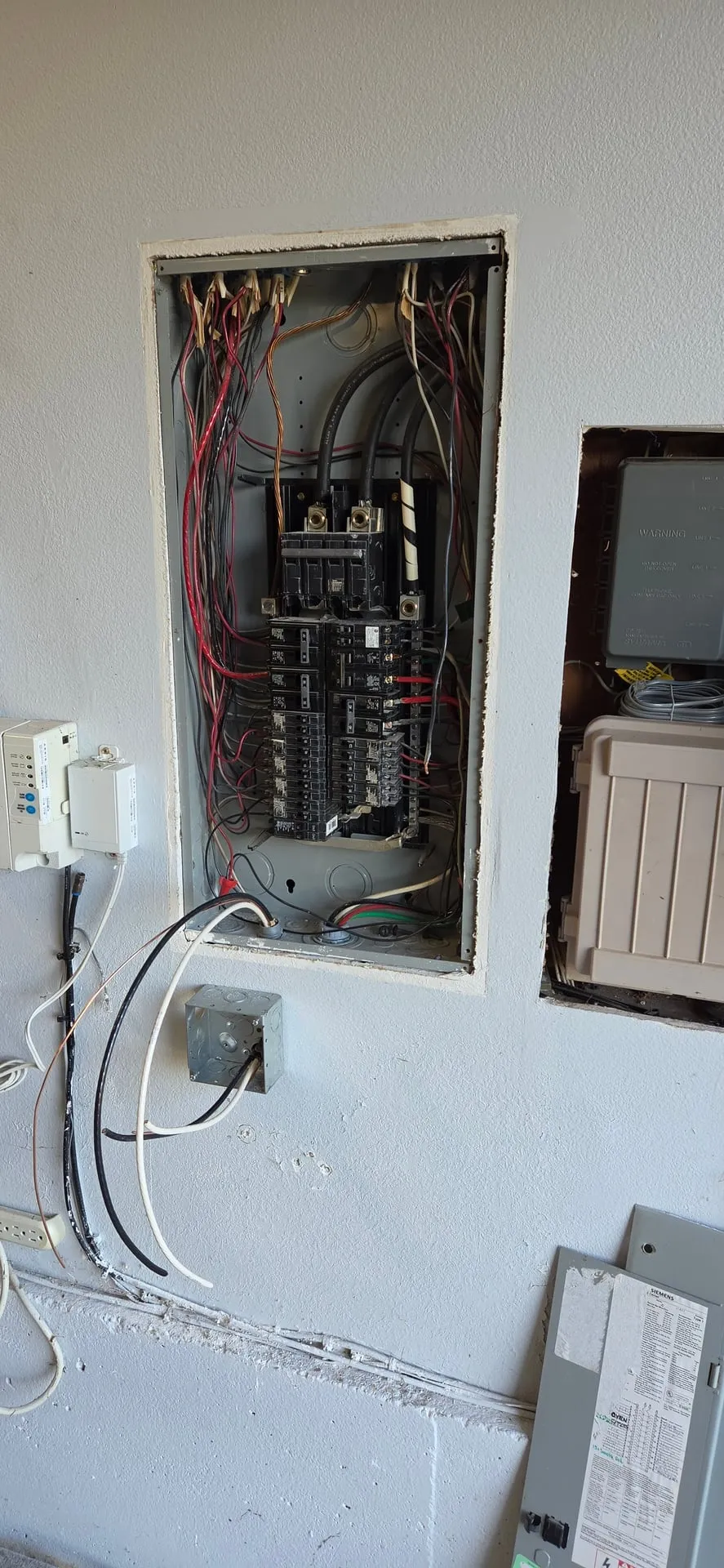 Siemens electrical panel with the cover off in a Camas WA garage before a tandem breaker and EV charger circuit were added