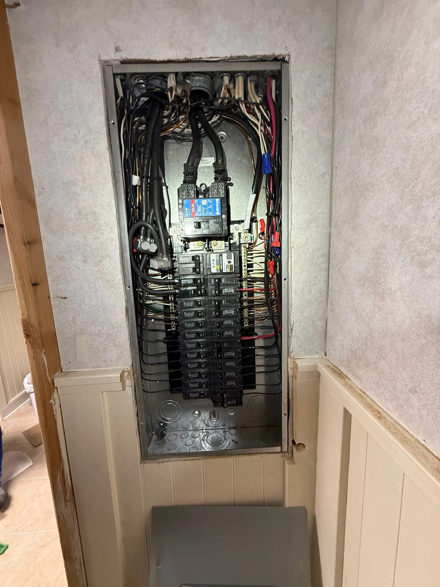 Second original electrical panel in a Vancouver WA hallway opened before replacement, showing crowded branch circuit conductors and aged breakers