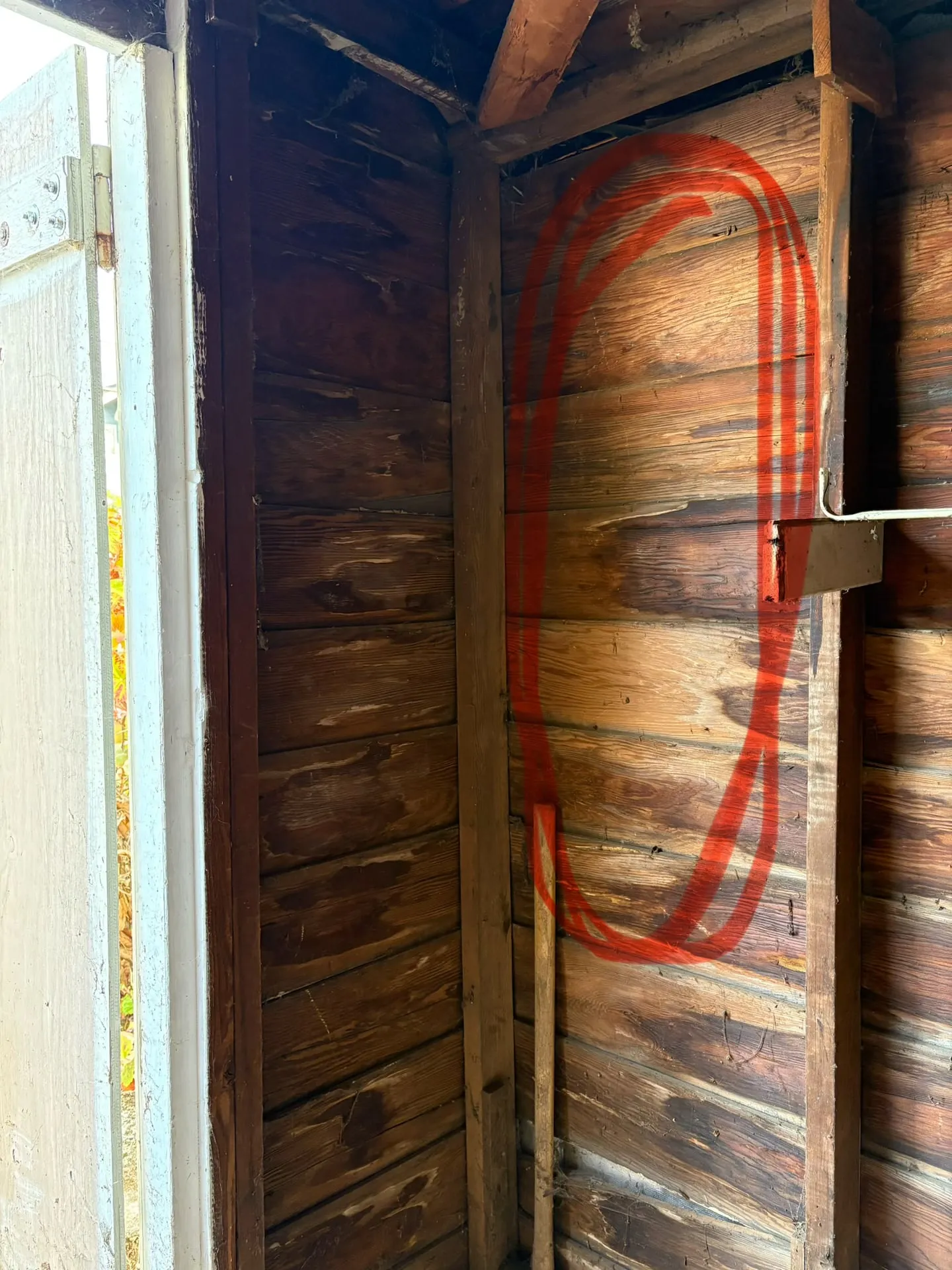 Orange spray paint outline on the wood wall of a detached garage in Washougal WA marking where the subpanel would go