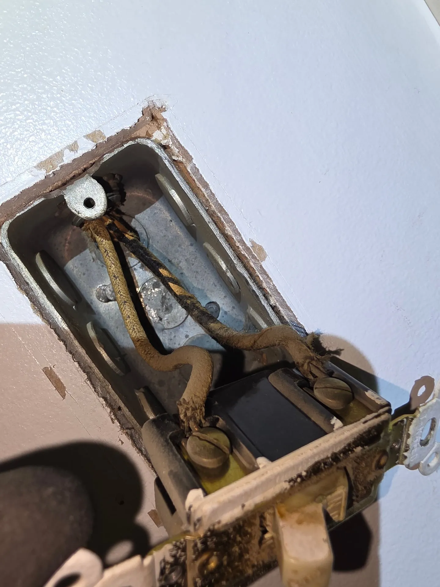 Old switch pulled from a metal box with burned, cloth-covered wiring in a Woodland WA home