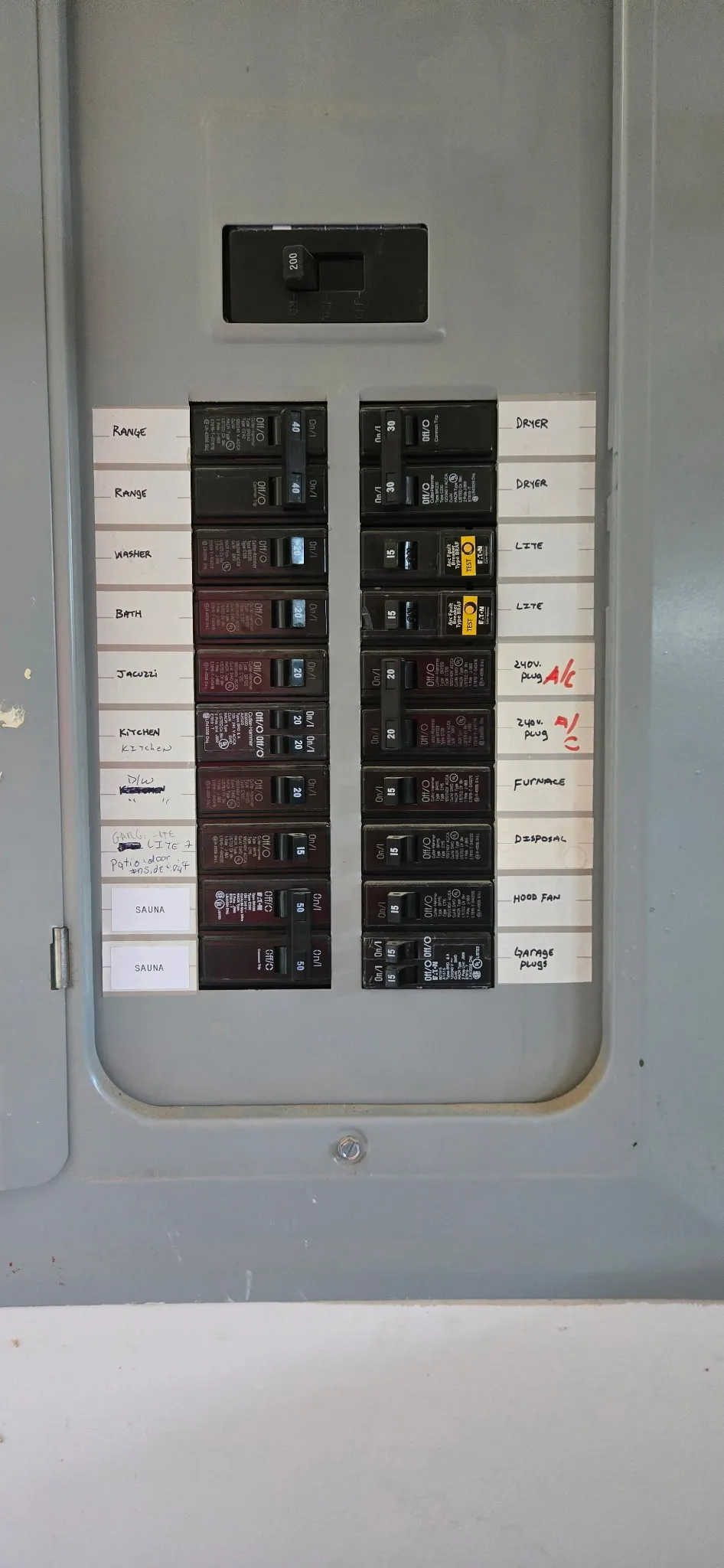 Open Eaton electrical panel in a Washougal WA home with a fully handwritten circuit directory and new breakers landed for the sauna heater and lighting circuits