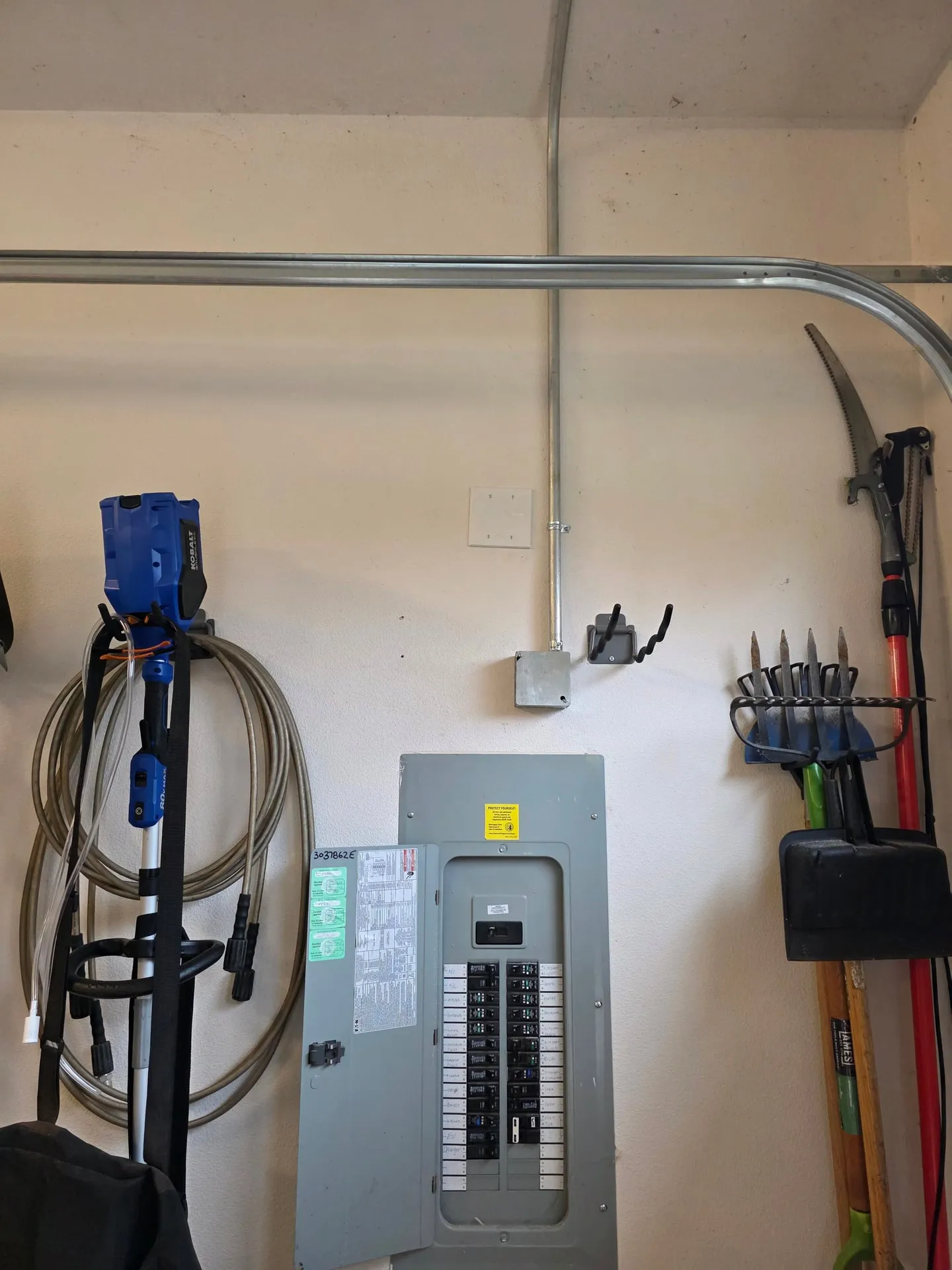 Metal EMT conduit running up from an Eaton electrical panel and across the garage wall in a Vancouver WA home