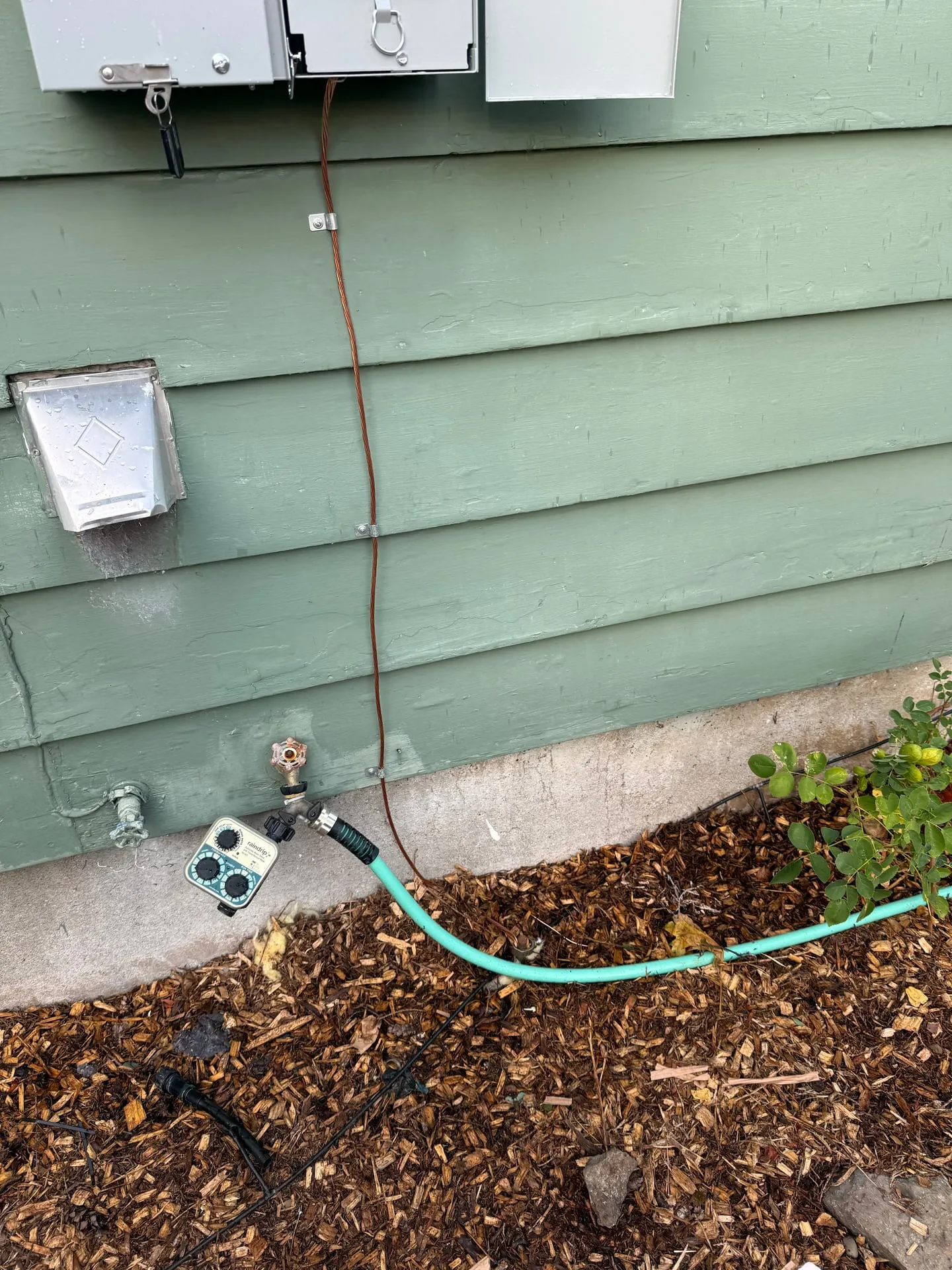 Bare copper grounding electrode conductor strapped down the siding from the bottom of the new meter main to the ground rod beside the foundation