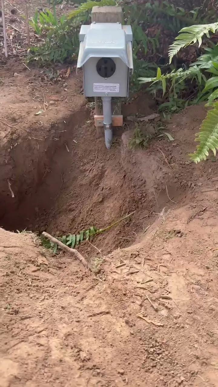 50-amp RV outlet in a gray weatherproof box with an in-use cover, mounted on a post at the end of a trench in a Kelso WA yard