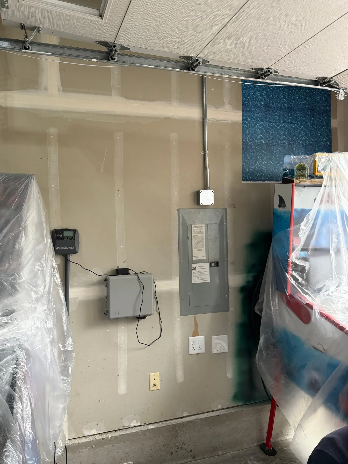 Eaton electrical panel on an unfinished garage wall in Washougal WA with new EMT conduit running up from it for added garage circuits