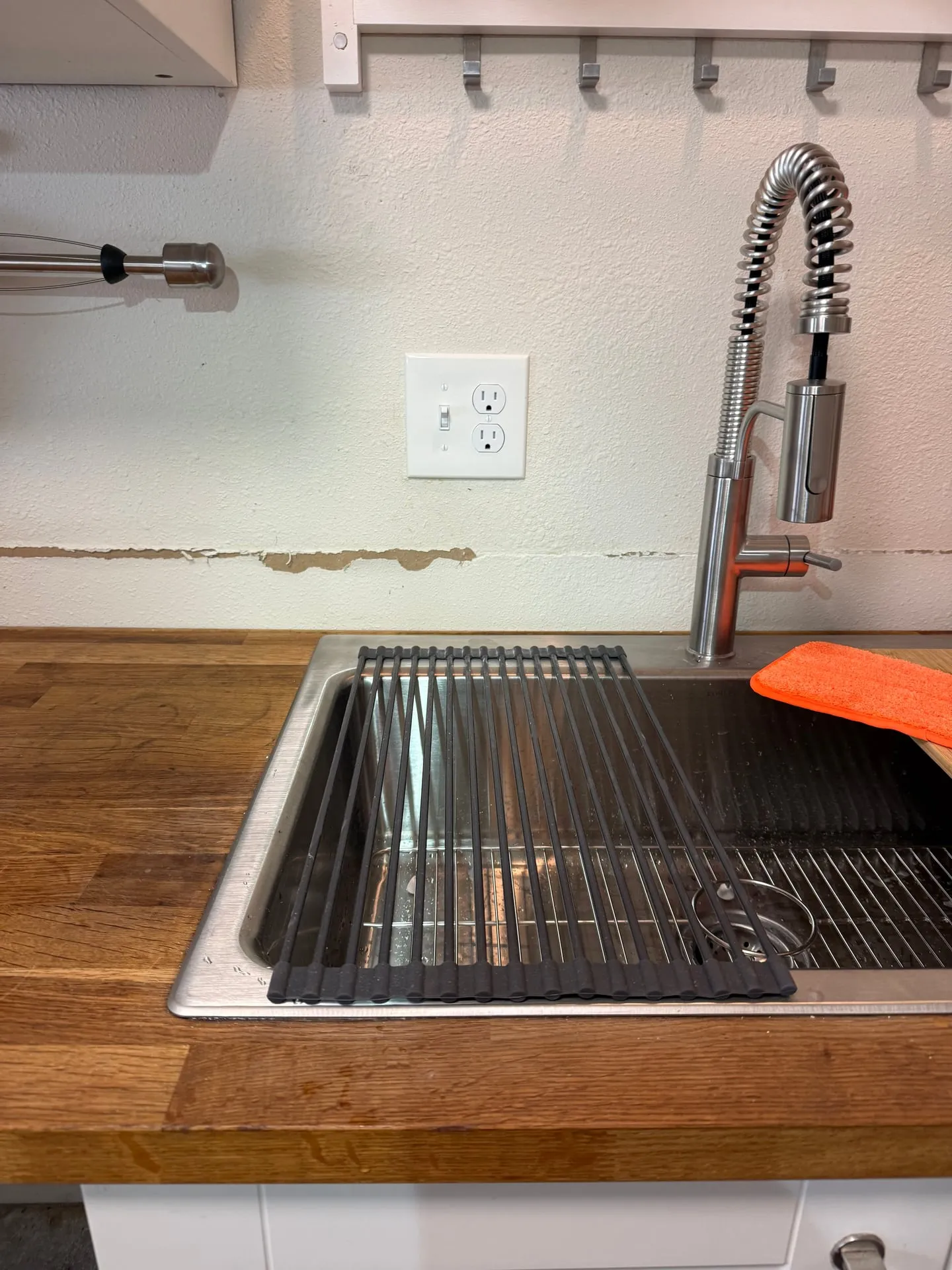 New GFCI receptacle installed above the counter beside a stainless sink in a downstairs kitchen in Vancouver WA, with a butcher block counter and pull-down faucet