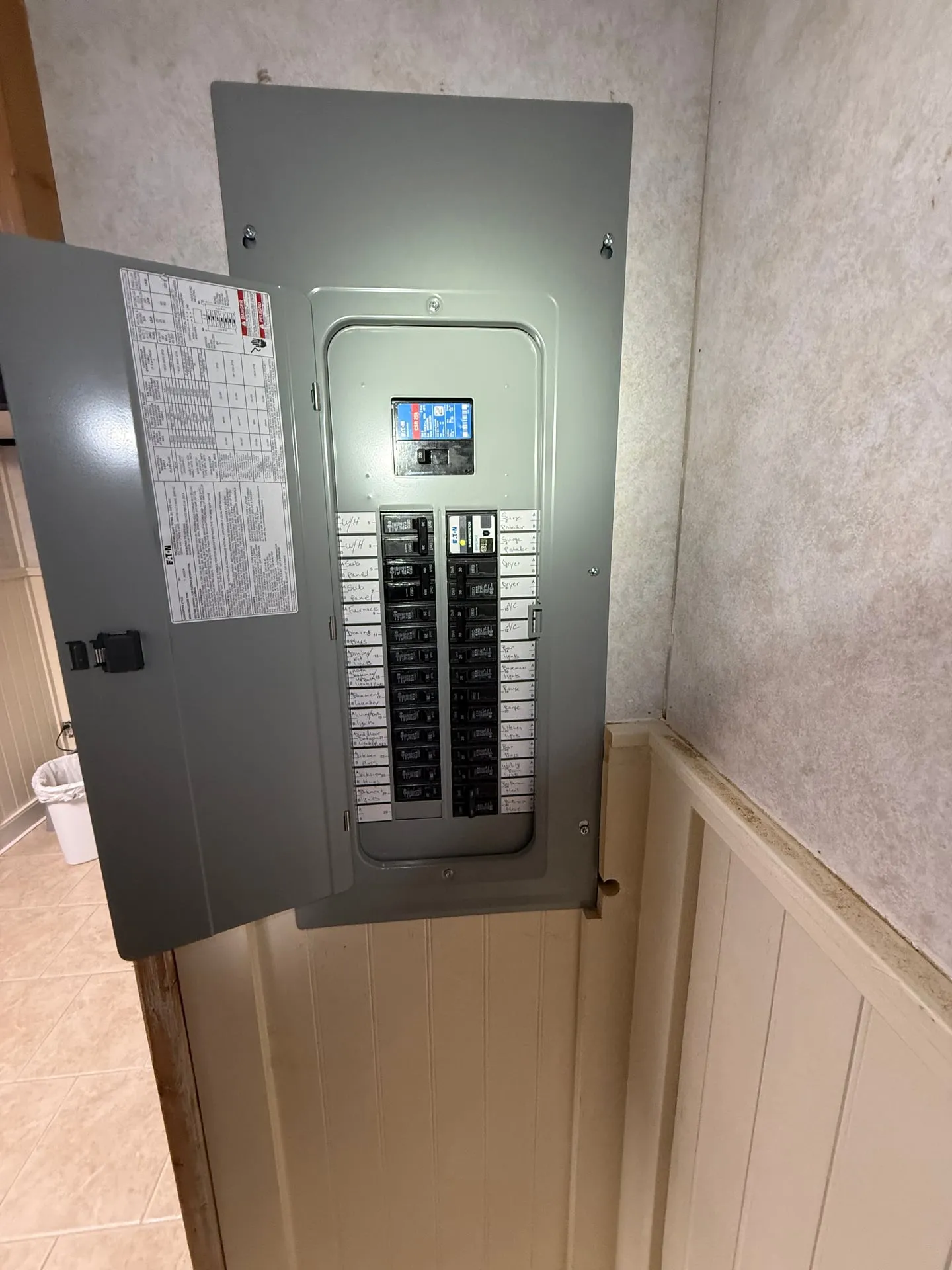 New electrical panel installed in the hallway of a Vancouver WA home with the door open, showing a typed circuit directory, a surge protective device with a status display, and every breaker labeled