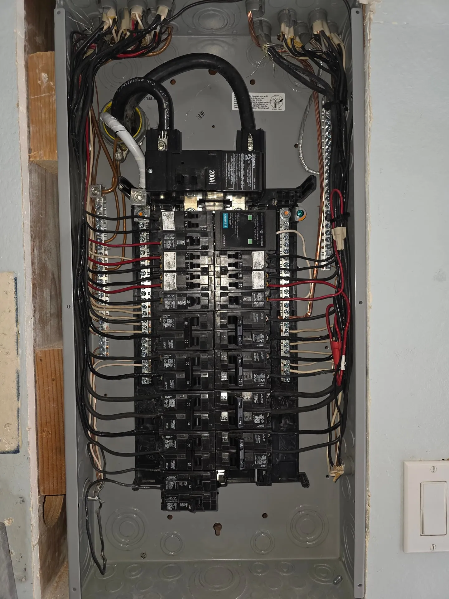 New Siemens 200-amp electrical panel installed in a Washougal WA home with the dead front removed, showing the 200A main breaker, a Siemens BoltShield surge protector, and every branch circuit landed neatly around the bus