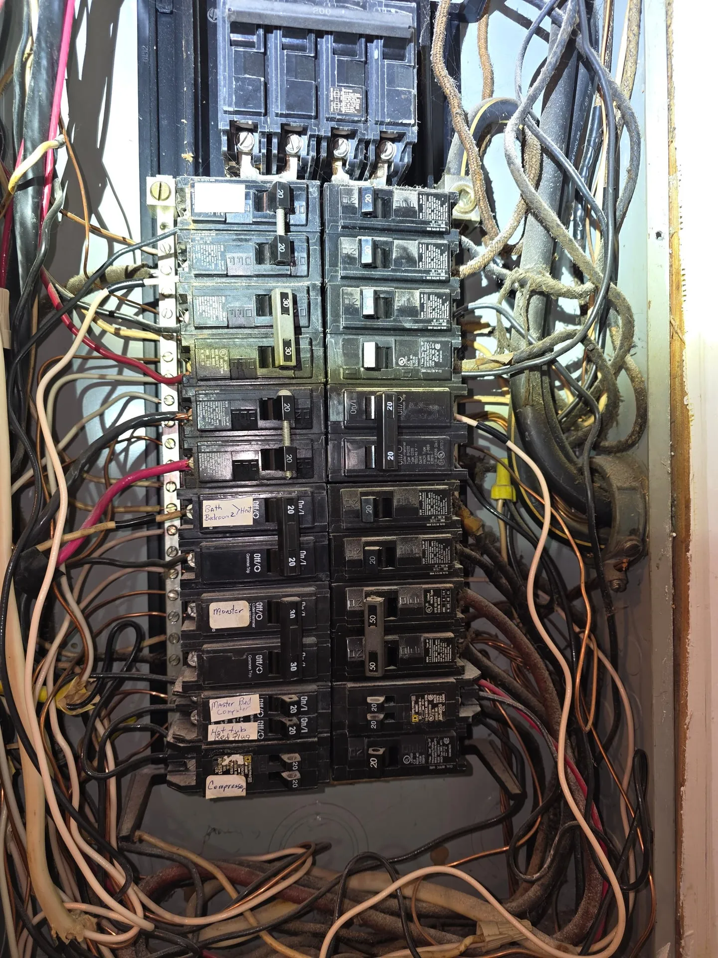 Square D Homeline panel with the cover off and crowded wiring in a Woodland WA home before new circuits were added