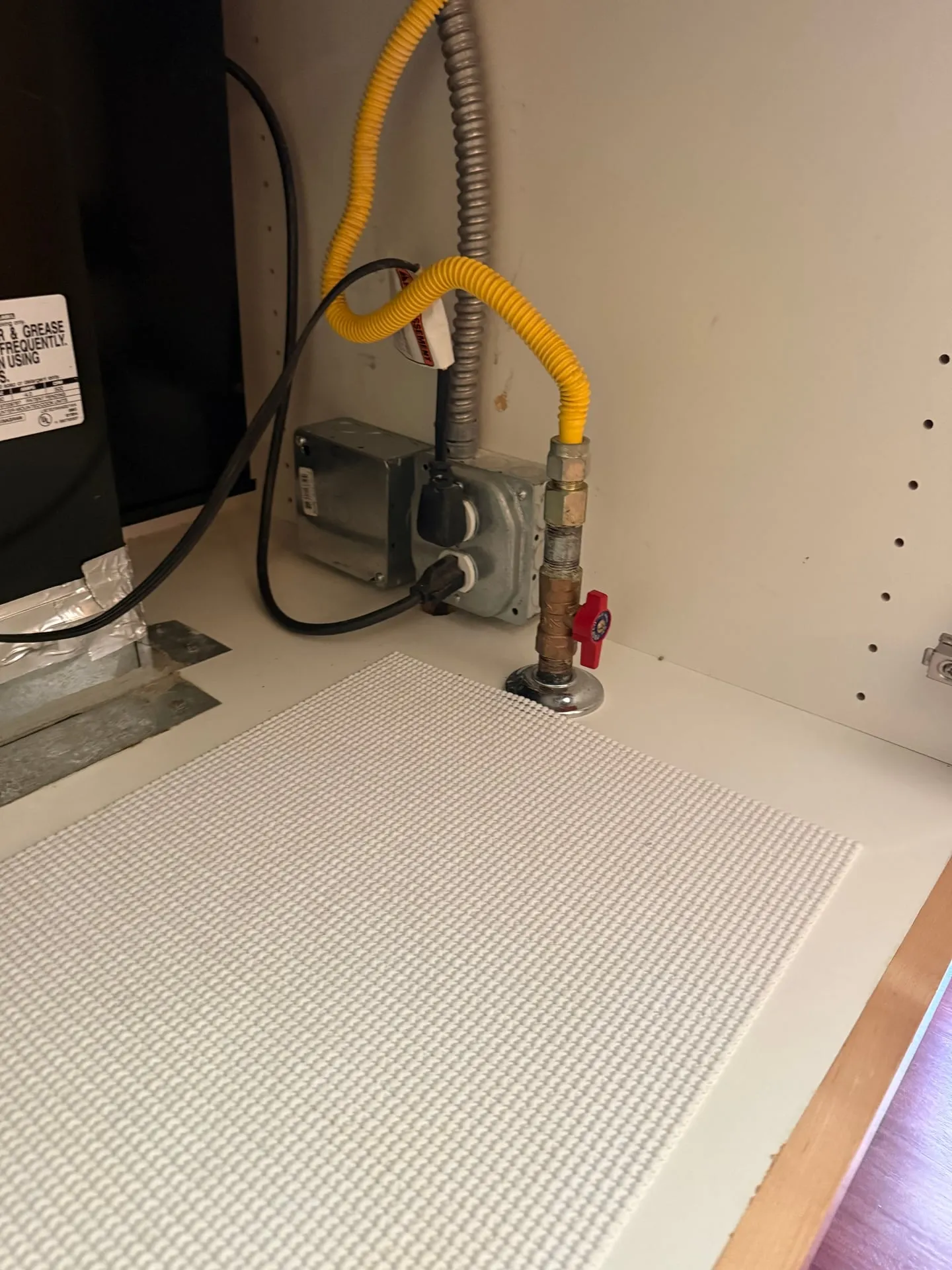 Counter cutout in a Vancouver WA kitchen showing the existing gas line and the new receptacle box installed below for an induction cooktop circuit