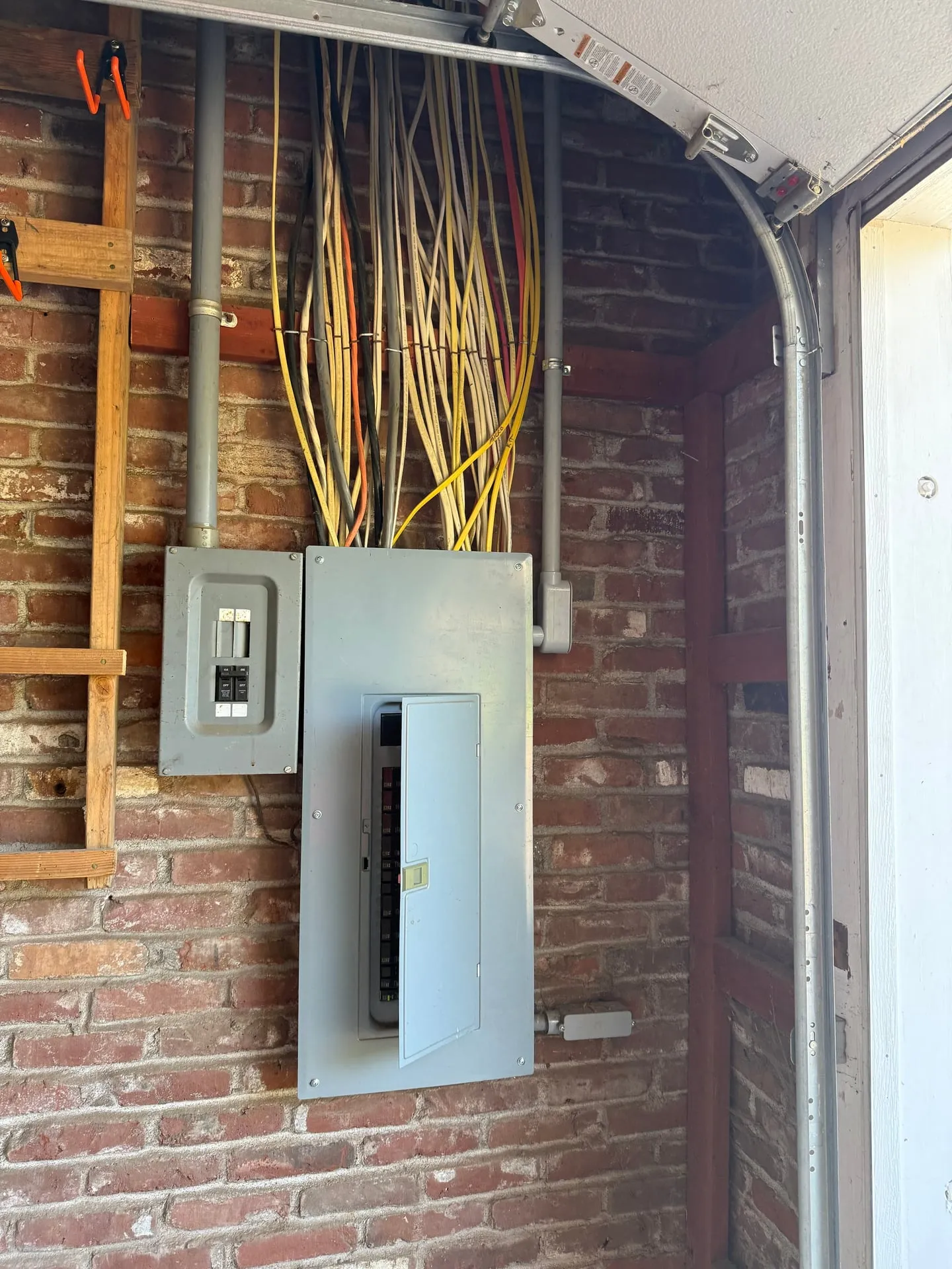 Existing main panel mounted on the brick exterior wall of a Vancouver WA home, with a second enclosure beside it where the new shed feeder was landed