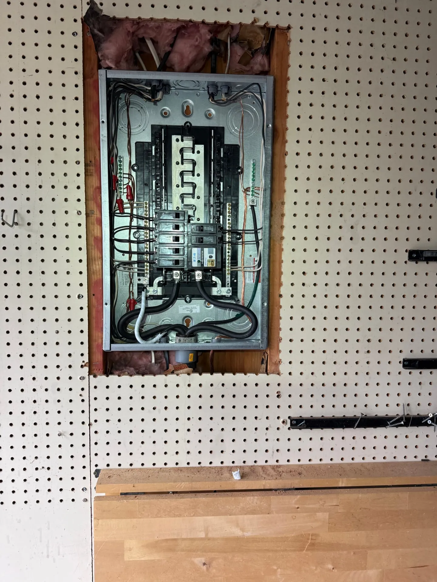 New electrical panel installed in the garage of a Vancouver WA home in the same pegboard opening the old Pushmatic occupied, with conductors landed neatly on the bus