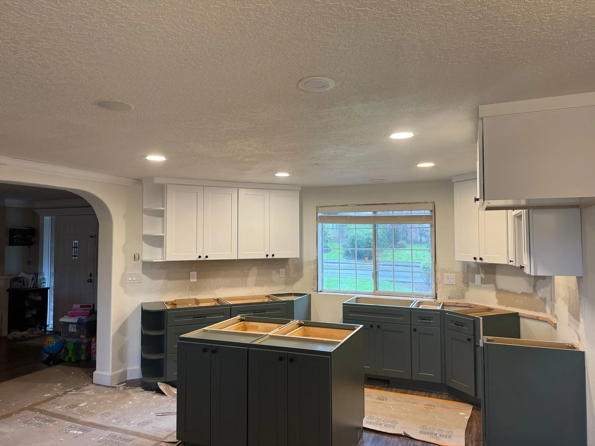 Newly installed canless LED downlights across the ceiling of a Vancouver WA kitchen during a remodel, with cabinets set and countertops not yet installed