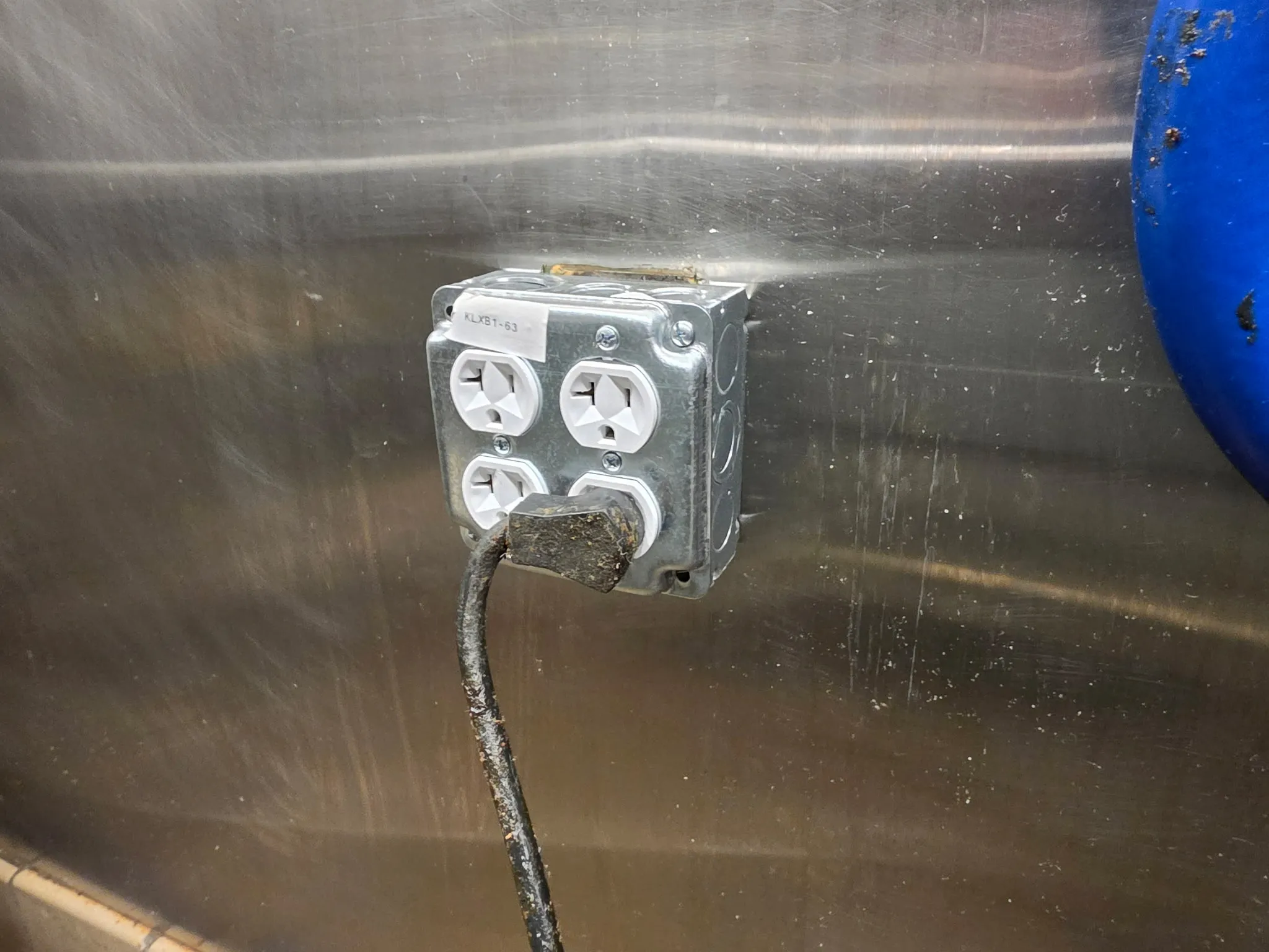 Close view of a new quad outlet in a metal box mounted on a stainless steel kitchen wall in a Ridgefield WA restaurant