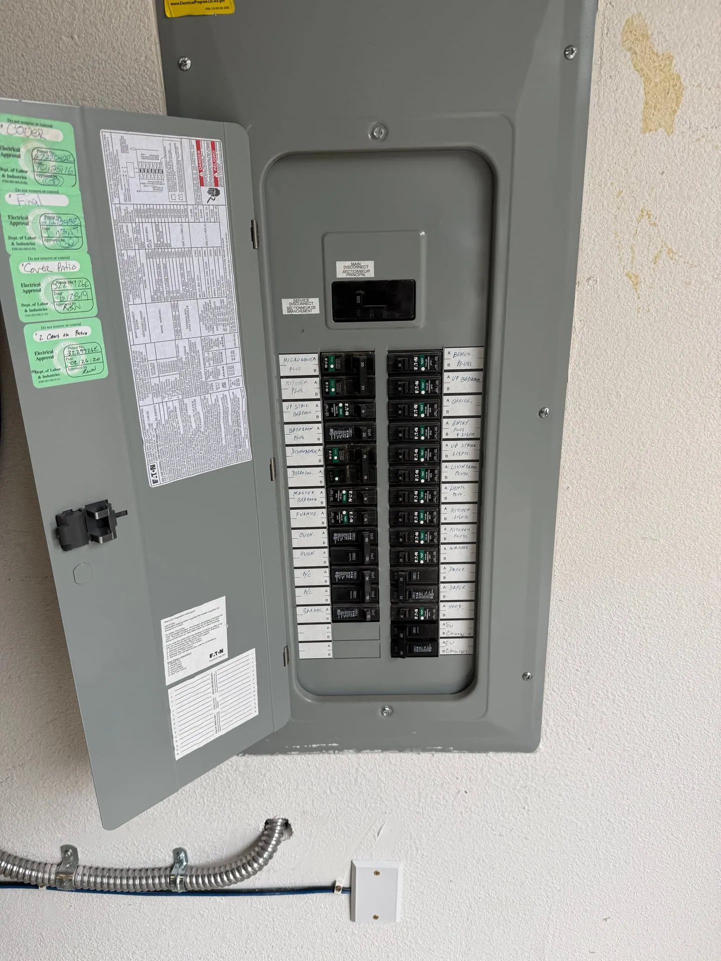Open electrical panel in a Camas WA garage showing the new dedicated two-pole breaker landed for the EV charger and the whip leaving the bottom of the enclosure