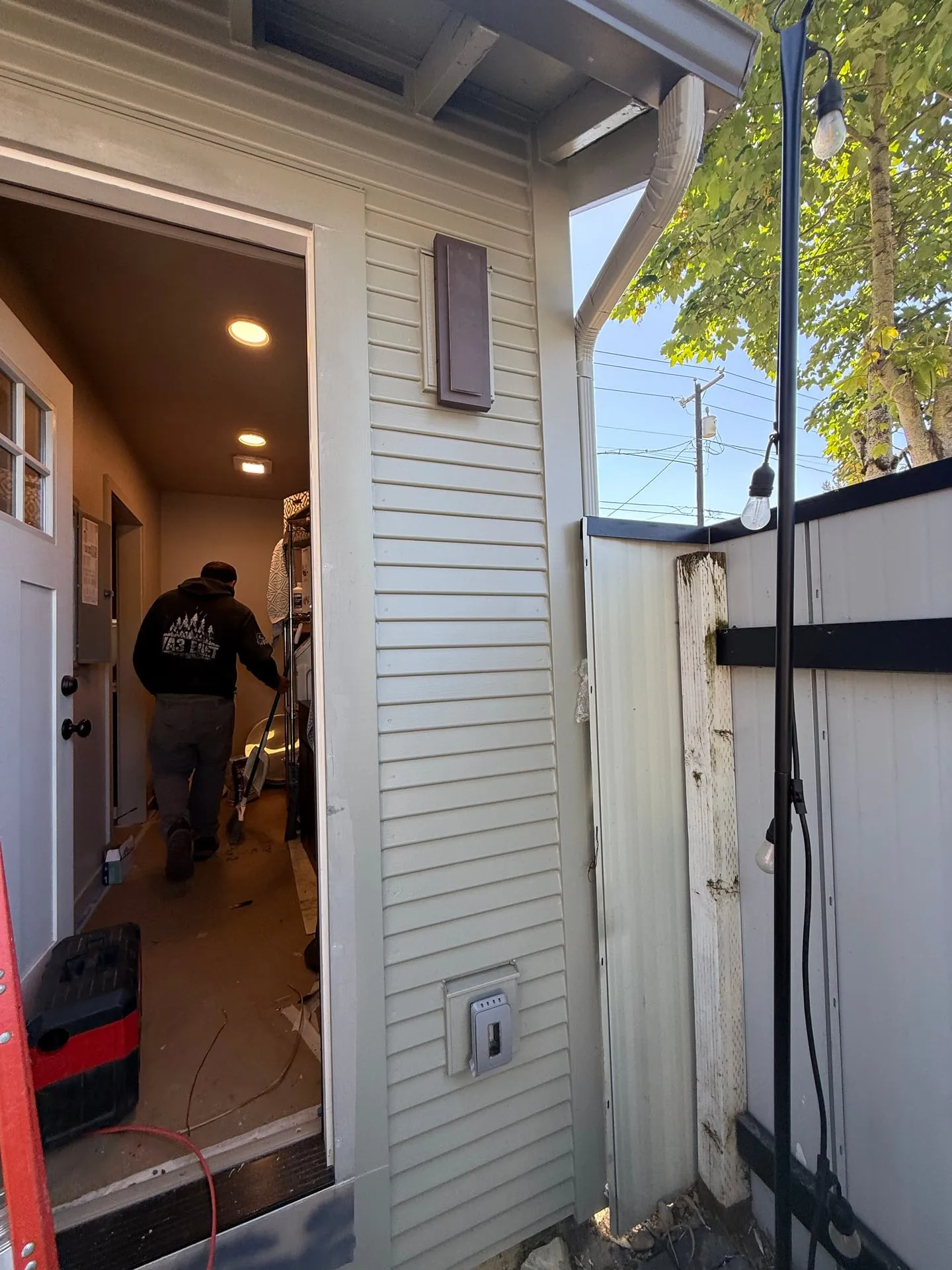 Exterior wall of a north Vancouver WA home showing the relocated electrical panel enclosure beside the back door during the rewire