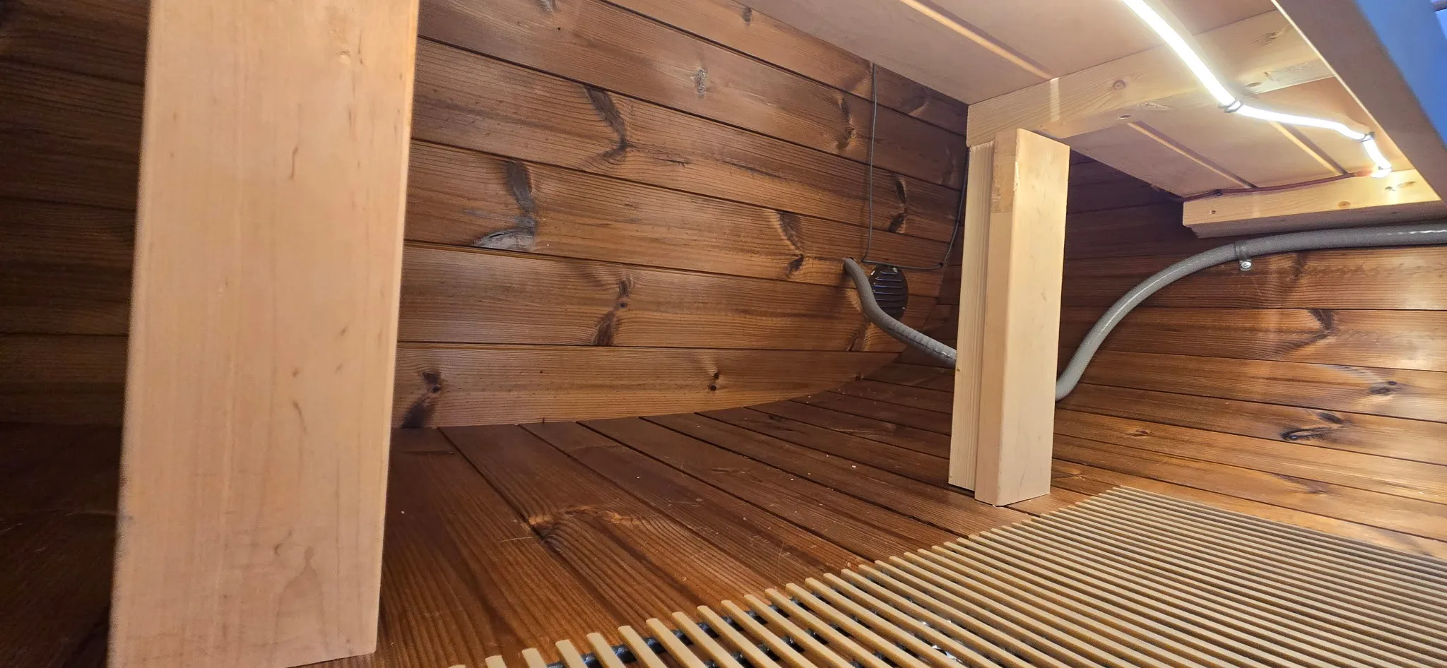 LED strip lighting installed under the cedar bench of an outdoor sauna in Washougal WA, casting warm light across the slatted floor