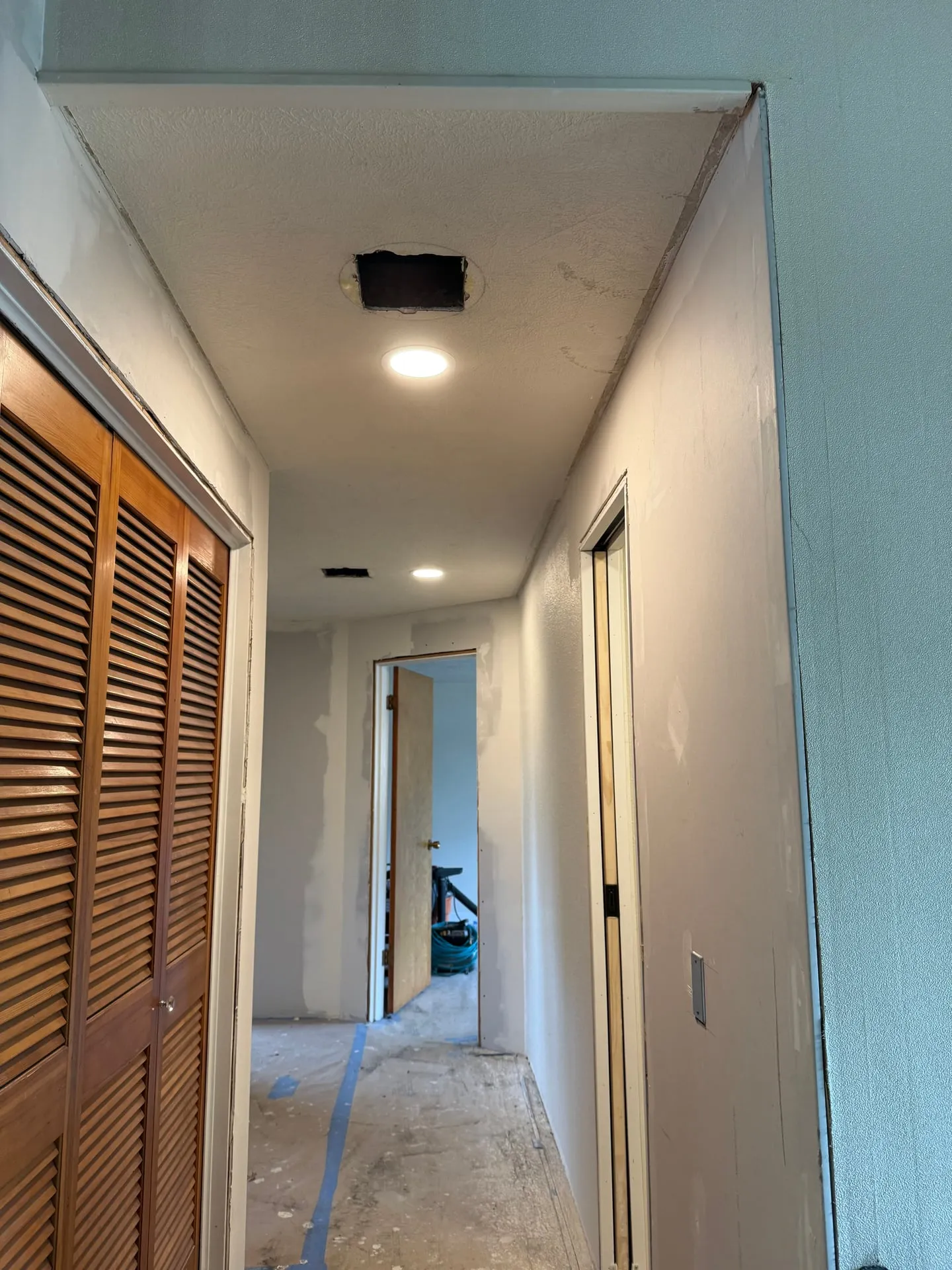 Upstairs hallway of a Hazel Dell home in Vancouver WA with new LED downlights installed in the ceiling and louvered closet doors along one side